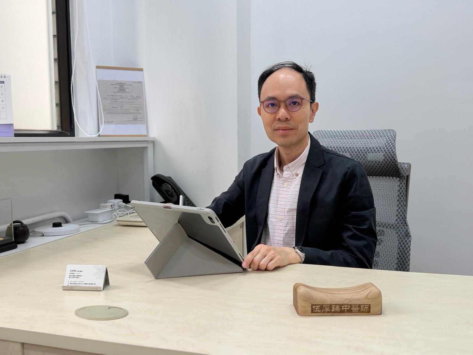 Dr. Ng Hau Jun taking a pulse in the consultation room